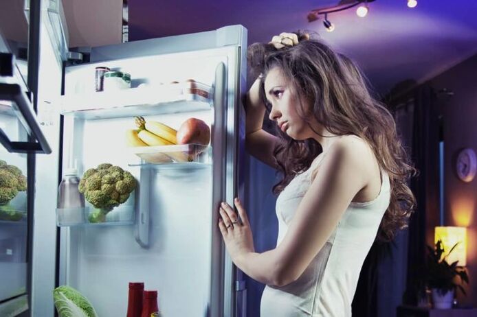 mergina prie šaldytuvo laikydamasi mėgstamos dietos
